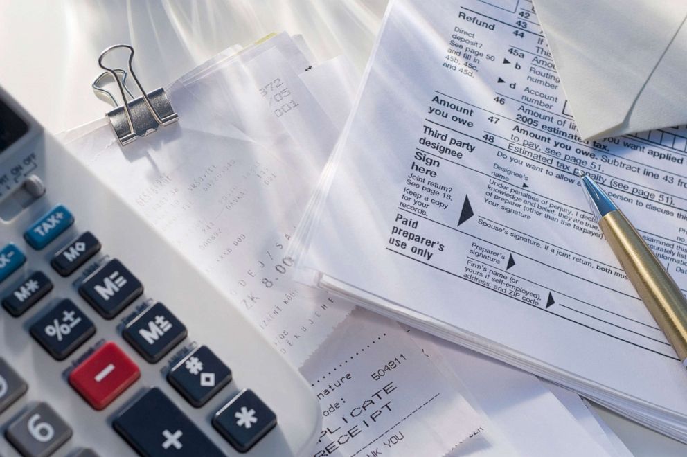 PHOTO: Tax return paper work sits next to a calculator in an undated stock image.
