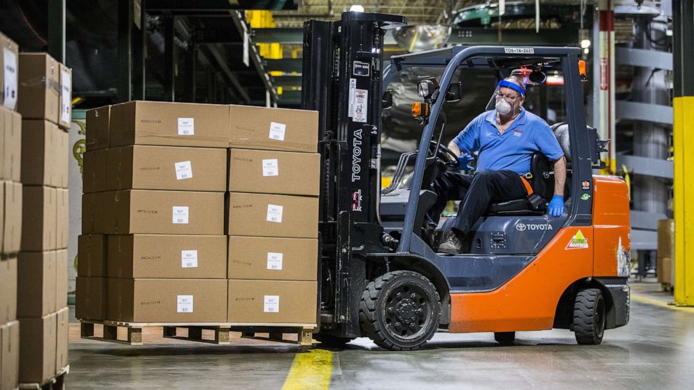PHOTO: A worker wearing a protective face mask operates a forklift to move boxes of face shields ready for shipment at a Hasbro manufacturing facility in East Longmeadow, Massachusetts, on Wednesday, April 29, 2020.