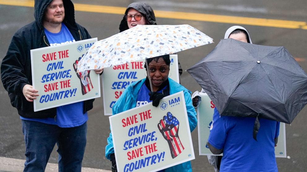 PHOTO: Labor union members hold placards on the day of a rally in support of federal workers during a rush hour protest outside the L'Enfant Plaza Metro Station in Washington, Mar. 24, 2025.