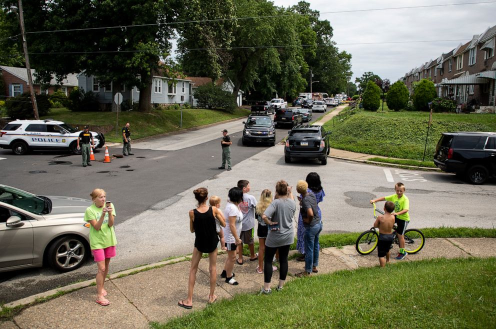 PHOTO: Community members gather as rescue personal remove the bodies of two workers who were found dead in a sewer manhole in Alden, Pa., July 11, 2019.