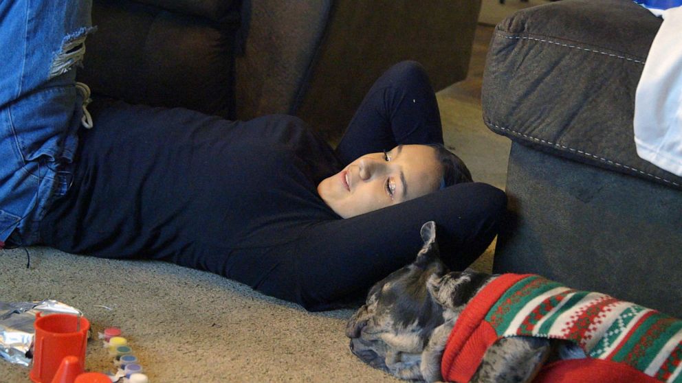 PHOTO: Miah laying on the carpet with her dog Pote during Christmas Eve in 2022 at her home in Uvalde, Texas.