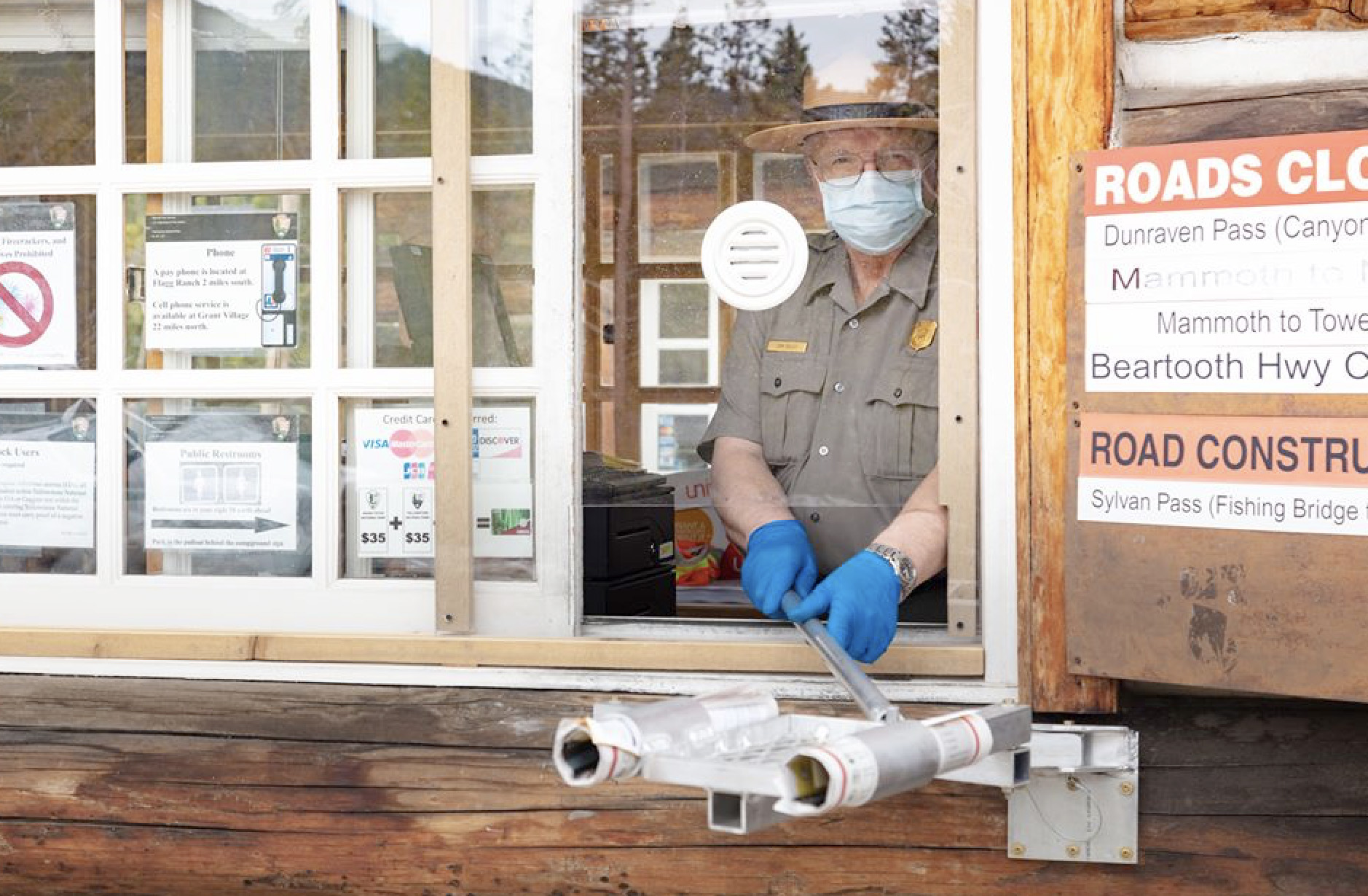 PHOTO: A park ranger with face mask and other precautions prepares to greet visitors at Yellowstone National Park ahead of Memorial Day weekend.