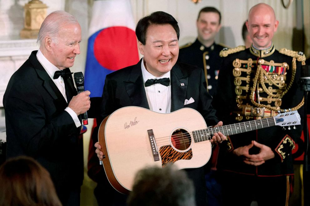 PHOTO: President Joe Biden gives a gift of a guitar signed by artist Don McLean to South Korea's President Yoon Suk Yeol at an official state dinner at the White House in April 26, 2023.