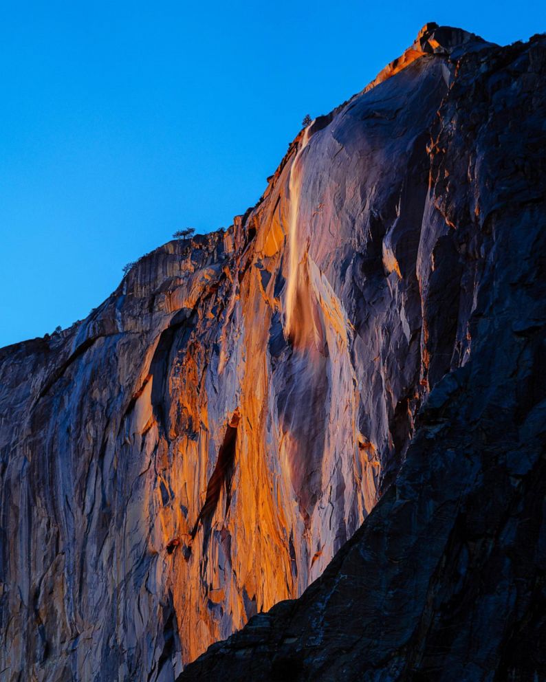 PHOTO: Water flowing off Horsetail Fall glows orange at sunset during in Yosemite National Park, Calif. on Feb. 13, 2023.