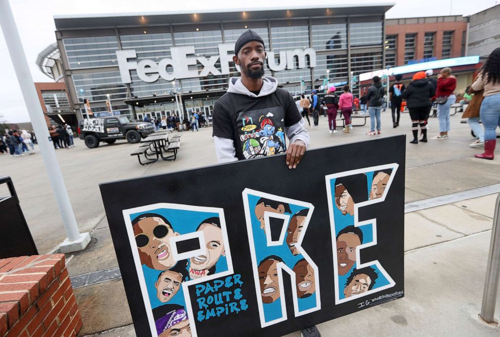 PHOTO: Barnus Young holds a painting he created for Young Dolph, outside of the FedExForum during a memorial celebration of the late rapper in Memphis, Tenn., Dec. 16, 2021.