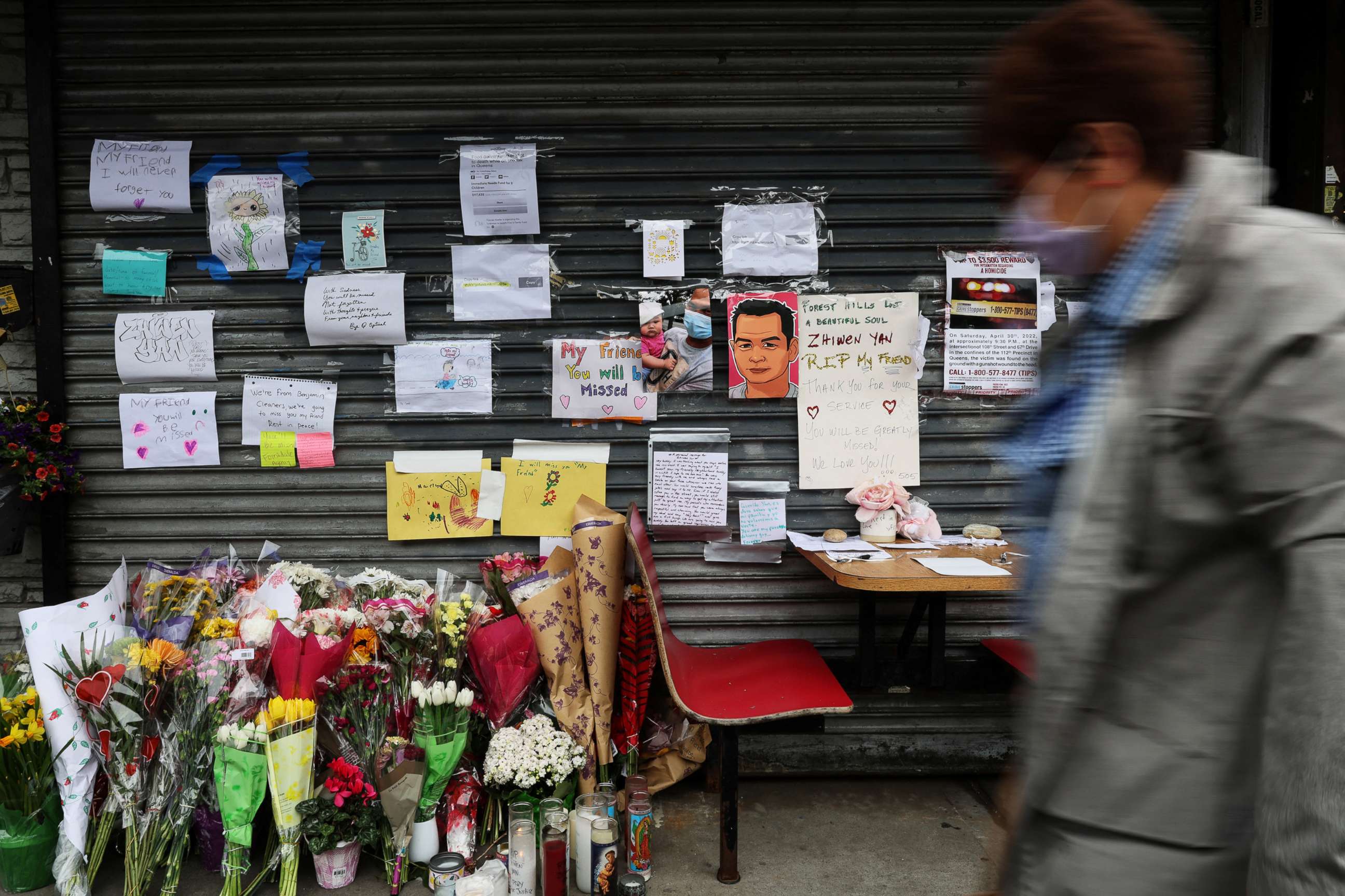 A person walks by a memorial for food delivery courier Zhiwen Yan,a 45-year-old Chinese immigrant fatally shot and killed on April 30, 2022, outside the Chinese restaurant where he worked in the Forest Hills neighborhood of Queens,New York on May 4, 2022.