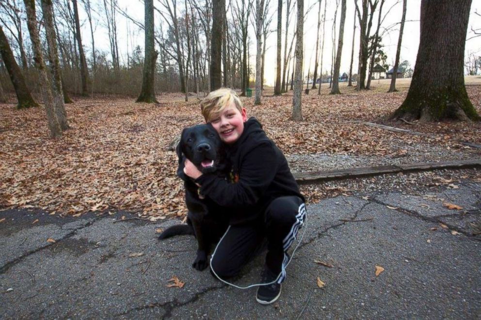 PHOTO: Eli Nichols hugs his dog, Einstein, who is trained to detect and alert when Eli's blood sugar is spiking or crashing, in Arlington, Tenn.