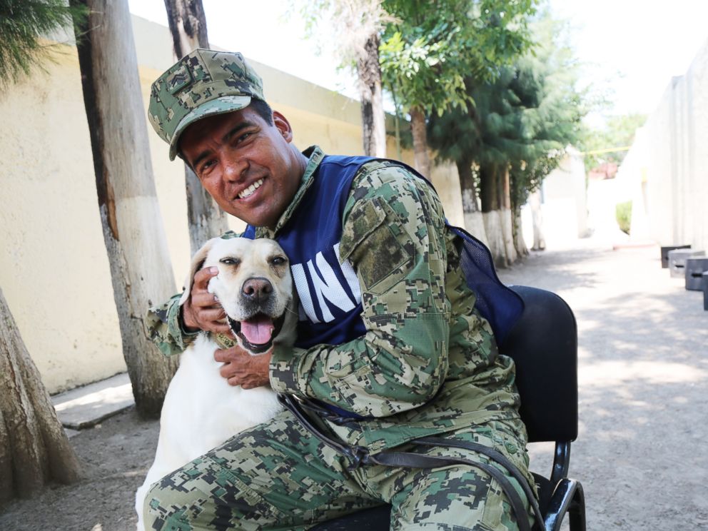 PHOTO: Israel Arauz Salinas hugs rescue dog Frida, who is his partner at the Mexican Navy Canine Unit.
