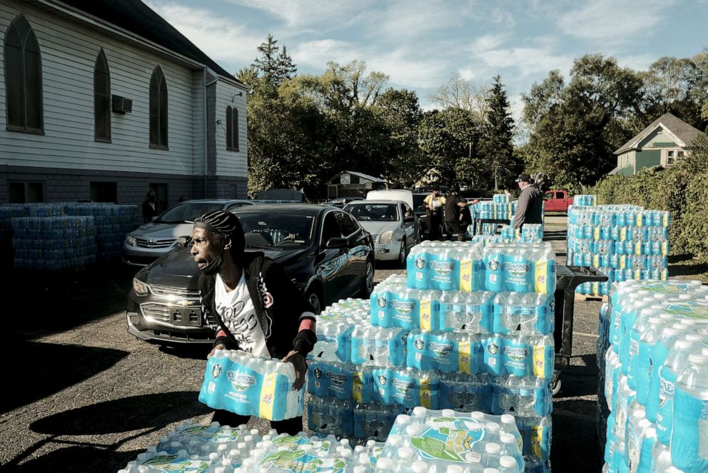 PHOTO: Volunteers distribute pallets of bottled water to residents at the Abundant Life Church of God in Benton Harbor, Mich., Oct. 19, 2021.