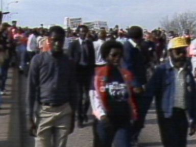 VIDEO: Civilians and public figures joins arms and march across the Edmund Pettis Bridge.