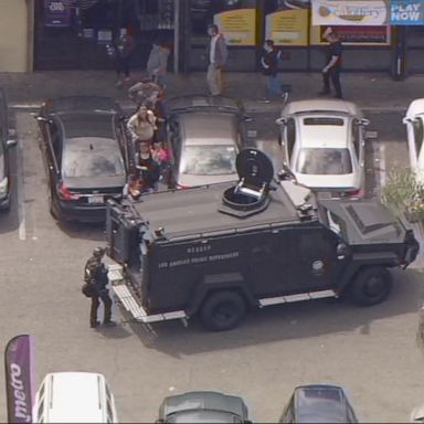 Police and SWAT units swarmed a strip mall in search of a shooting suspect believed to be barricaded inside a store.