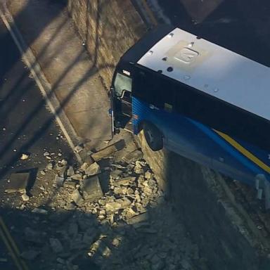 NYC bus hangs off overpass after crash into guardrail