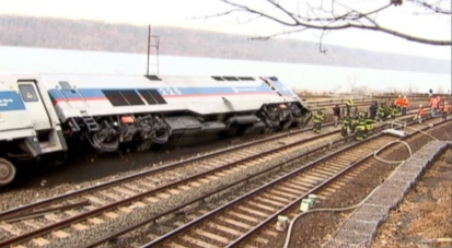 Commuter train on busy holiday weekend slips off tracks, rolls over, leaving at least four dead.