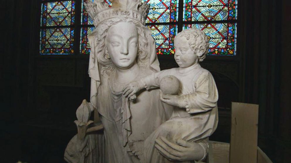 PHOTO: A statue that survived the fire at Paris' Notre Dame cathedral sits in front of a stained glass window.