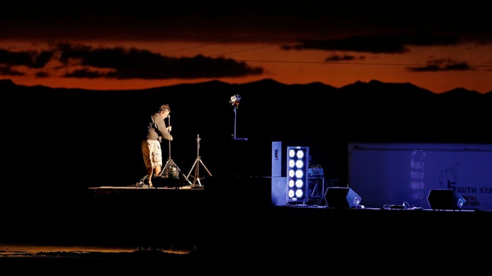 A man sets up a stage in preparation for an event inspired by the "Storm Area 51" internet hoax near the Little A'Le'Inn motel and cafe, Thursday, Sept. 19, 2019, in Rachel, Nev. Hundreds have arrived in the desert after a Facebook post inviting peop