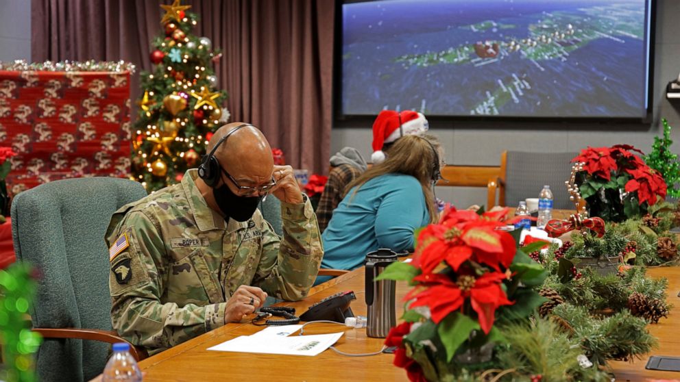 In this photo released by the U.S. Department of Defense, volunteers answer phones and emails from children around the globe during annual NORAD Tracks Santa event at Peterson Air Force Base in Colorado Springs, Colo., on Dec. 24, 2021. The U.S. mili