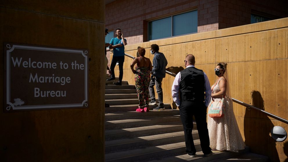 Couples wait in line for marriage licenses at the Marriage License Bureau, Friday, April 2, 2021, in Las Vegas. The bureau was seeing busier than normal traffic ahead of 4/3/21, a popular day to get married in Las Vegas. (AP Photo/John Locher)