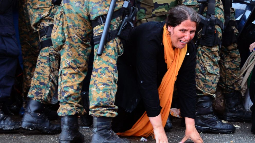 A woman cries as she crawls through a block of border police in the southern Macedonian town of Gevgelija, Sept. 10, 2015.
